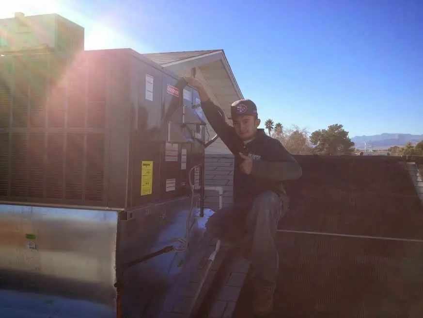 HVAC technician performing HVAC Inspection on a rooftop unit in Absecon